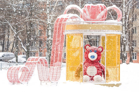 Winter. Snow is falling. Beautiful holiday decorations on the street in the city. A great gift and a teddy bear. Beautiful Christmas background. The concept of decorations and decor for the new year.の写真素材