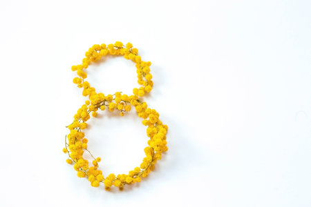 International Women's Day. A banner, a flyer, a beautiful postcard for March 8th. Yellow mimosa flowers in the shape of the number eight on a white isolated background.の写真素材
