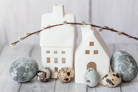 Stylish gray Easter eggs in the colors of marble, concrete, willow branches and white houses in...