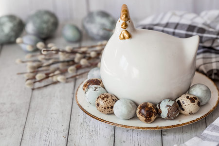 Stylish gray Easter eggs in the colors of marble, concrete, willow branches and Easter chicken on a...