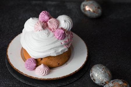 Beautiful still stylish life. Easter cake with meringue, marshmallows, and Easter eggs on a dark background. Happy Easter 2024.の写真素材