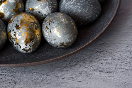 Stylish gray Easter eggs made of marble and concrete with a golden potala on a gray background. Coloring eggs with natural dye karkade tea. Environmental friendliness. Naturalness. The concept of a happy Easter.の写真素材