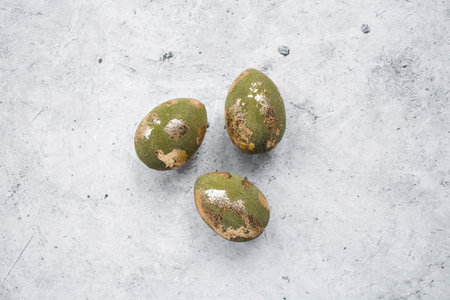 Stylish olive-colored Easter eggs with a coating of golden sweat on a gray background. The concept...