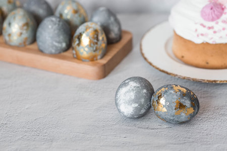 Stylish gray Easter eggs made of marble and concrete with a golden potala on a gray background....