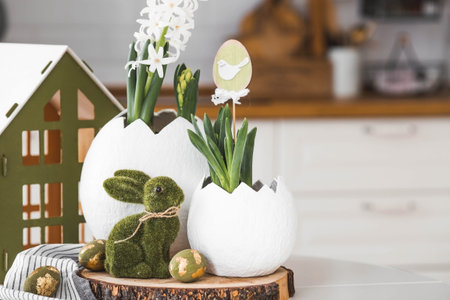 Happy Easter holiday. A spring hyacinth flower in an egg-shaped vase, Easter bunnies and eggs with a...