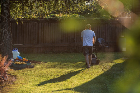 Banner. A human lawn mower cuts the grass in the backyard. Agricultural machinery for the care of the garden.の写真素材