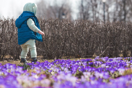 ?heerful little boy of two years old walks with his mother on the street in the spring. The kid...