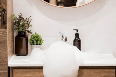 Modern bathroom interior with washbasin and faucet. Panoramic view of a soap dispenser in a bottle...