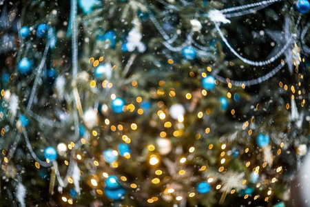 Abstract blurred glare of the side on the Christmas tree in warm shades of yellow. Beautiful New...