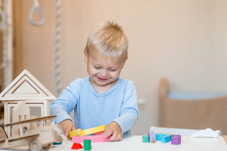 A little boy of 2 years old is playing a developing logistics constructor. Children's wooden toys. Montessori for child development.の写真素材