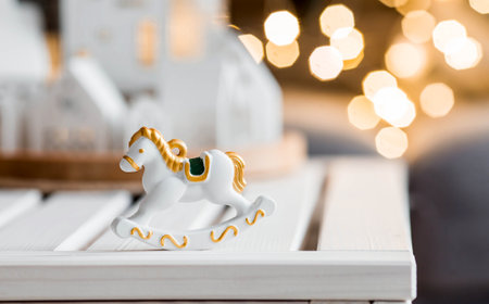 A spruce bouquet with green paper toys, a horse and white Scandinavian houses on the table in the living room. New Year's decor in the interior. The concept of preparing for the New Year's holiday 2025.の写真素材