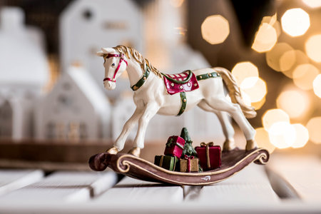 A spruce bouquet with green paper toys, a horse and white Scandinavian houses on the table in the living room. New Year's decor in the interior. The concept of preparing for the New Year's holiday 2025.の写真素材