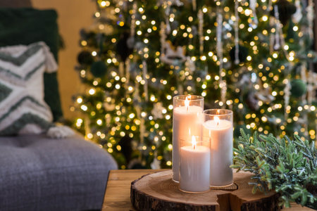 Christmas Eve. A candle on the table in the living room and a fir wreath. New Year's decor in the interior. The concept of preparing the house for Christmas and New year.の写真素材