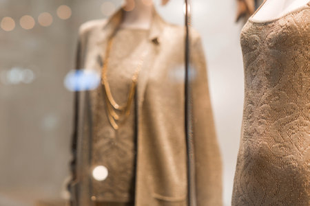 A showcase of a luxury store with mannequins in clothes and evening lighting. The concept of shopping and sales.の写真素材