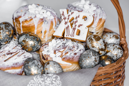 Banner for Easter. Easter eggs with gold accents and Easter cakes in a woven basket made of vines.の写真素材