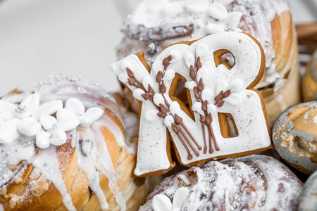 Easter themed baked goods decorated with white icing and gold accents, featuring decorated cookies and pastries with intricate designs.の写真素材