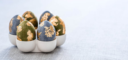 The banner. Table setting. An egg stand with a rabbit, and Easter eggs with gilding on a linen...