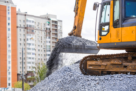 Heavy machinery for construction and landscaping. An excavator on a construction site in close-up. An excavator loads crushed stone into a bucket for construction.の写真素材
