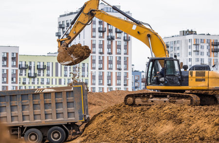 An excavator on a construction site in close-up. An excavator digs the ground with a bucket for...