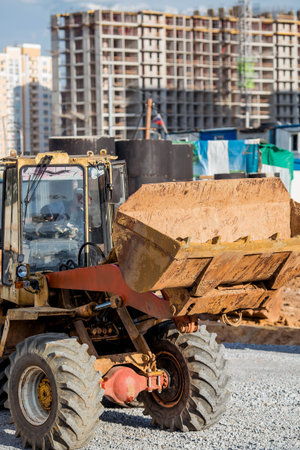 A tractor on a construction site in close-up. Heavy machinery for construction and landscape design.
