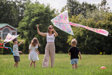 A family with three children. A mother with many children and toddlers in a summer park. Children...