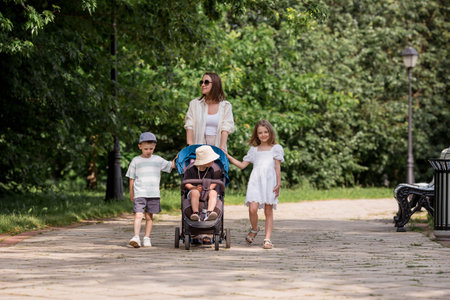 A family with three children. A mother with many children and toddlers in a summer park. Children...