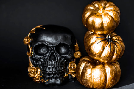 Halloween celebration. Black skull with golden roses and pumpkins. Decor for the Day of the Dead or Halloween on a black background.の写真素材