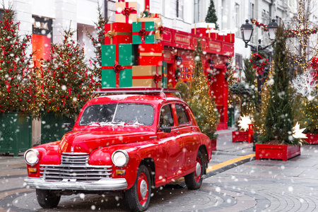 The concept of delivering gifts and goods. Christmas gifts are delivered on the roof of a red Christmas retro car. Decorated New Year's Moscow.の写真素材