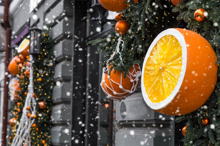 Mandarins in a string bag and Christmas tree decorations on the streets of Moscow. Happy New Year 2026. The concept of preparing decorations and ornaments for Christmas.の写真素材