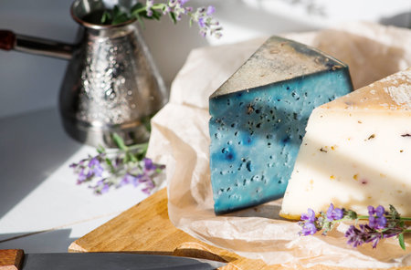 A piece of blue, fresh, aged, natural farm cheese with lavender on a wooden board. Unusual taste and quality of farm-fresh agricultural products.の写真素材
