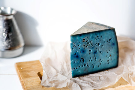 A piece of blue, fresh, aged, natural farm cheese with lavender on a wooden board. Unusual taste and quality of farm-fresh agricultural products.の写真素材