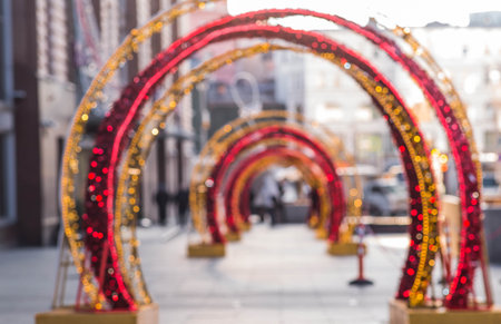 Blurry holiday background. Christmas street decorations, glowing arch and lights, beautiful bokeh.の写真素材