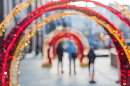 Blurry holiday background. Christmas street decorations, glowing arch and lights, beautiful bokeh.