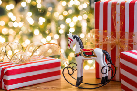 Stylish gift boxes and a horse on the background of a Christmas tree in a home interior of a living room. A cozy concept for the Christmas holidays. We are preparing gifts for our loved ones.の写真素材