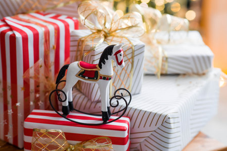Stylish gift boxes and a horse on the background of a Christmas tree in a home interior of a living room. A cozy concept for the Christmas holidays. We are preparing gifts for our loved ones.の写真素材