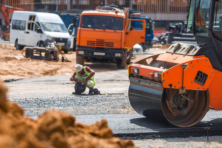Heavy equipment for earthworks and landscaping. Close-up of a road roller compacting asphalt....