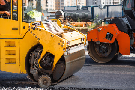 Heavy equipment for earthworks and landscaping. Close-up of a road roller compacting asphalt....