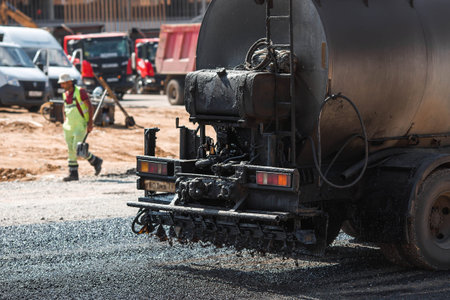 Heavy equipment for earthworks and landscaping. Close-up of a tanker truck with bitumen. Preparing for asphalt laying. Road construction.の写真素材