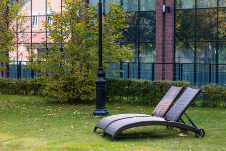 Banner. Two sun loungers on a green lawn in the hotel courtyard. The concept of rest, relaxation,...
