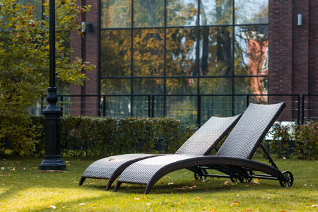 Banner. Two sun loungers on a green lawn in the hotel courtyard. The concept of rest, relaxation,...