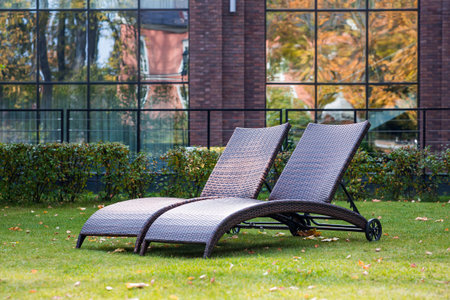 Banner. Two sun loungers on a green lawn in the hotel courtyard. The concept of rest, relaxation,...
