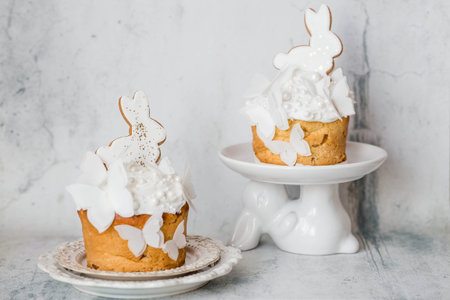 Stylish Easter still life. Easter cake with a white rabbit and airy rice paper butterflies on a...