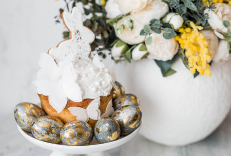 Stylish Easter still life. Easter cake with white rabbit and butterflies, Easter eggs with gold and...