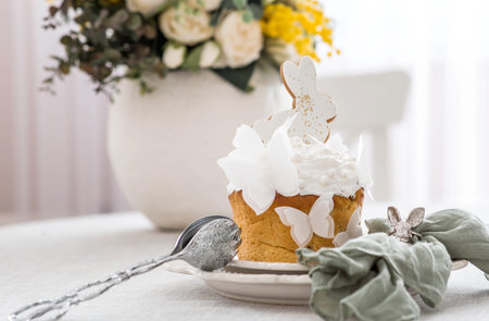 Stylish Easter still life. Easter cake with a white rabbit, butterflies and a spring bouquet of...
