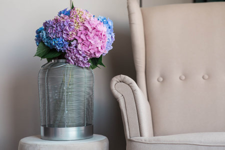 Multicolored hydrangeas in the interior of a cozy living room. A bouquet of garden plants. A landscape design concept for a house.の写真素材