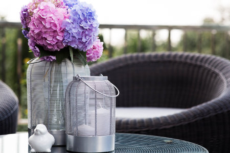 Multicolored hydrangeas in the interior of a cozy terrace or patio. A bouquet of garden plants. The concept of landscape design for a house.の写真素材