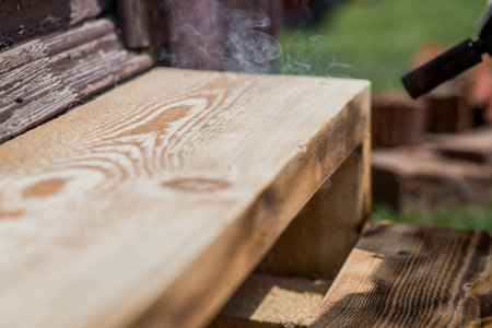 The texture of wood treated with fire using a burner. The process of burning wooden boards. Close-up.の写真素材