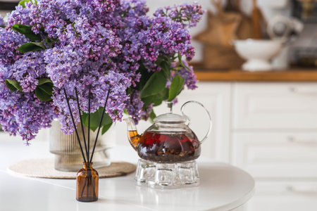 Aromatherapy, cozy atmosphere, comfort and relaxation. The aroma diffuser. Lilac-scented spring perfumes for the home in a glass bottle with chopsticks as an air freshener in the house.の写真素材