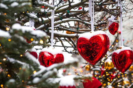 A festive background with red hearts hanging on ribbons in the city streets. Festive decorations. Valentine's Day. Love.の写真素材