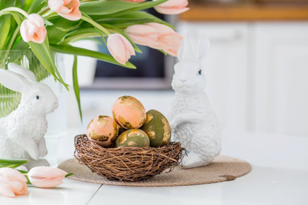 Beautiful Easter greeting card. A bouquet of delicate tulips, Easter bunnies, and golden-patterned...